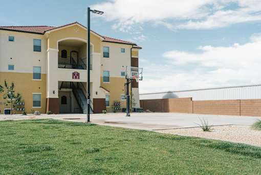 A building with a basketball hoop in front of it.