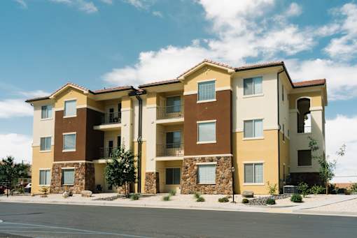 A row of apartment buildings with balconies and stone pillars.