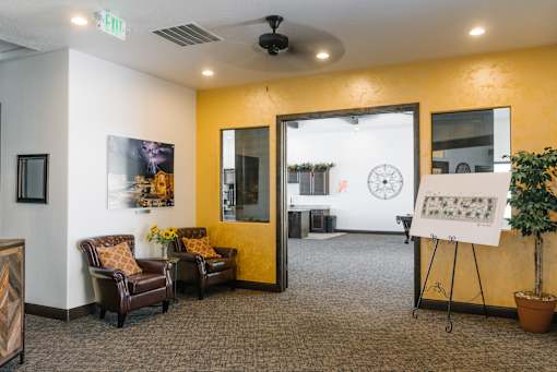 A room with a yellow wall and a whiteboard on a stand.