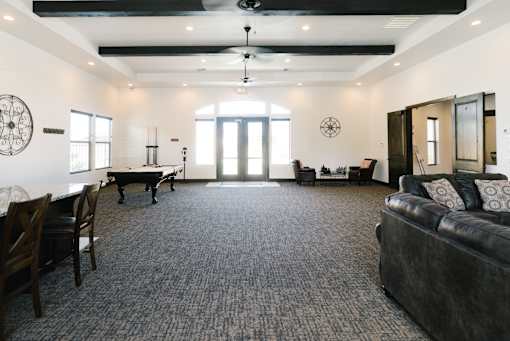 A living room with a black couch and a piano.