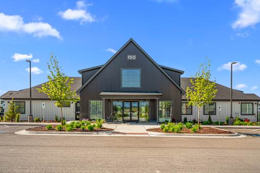 A modern building with a dark grey exterior and a large glass entrance at Silverbrook Apartments, Kalispell, Montana 59901