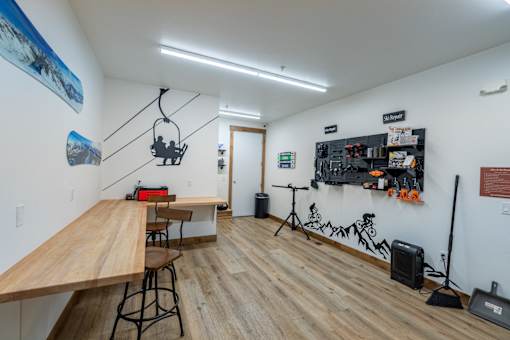 A room with a long wooden table and a bench. at Silverbrook Apartments, Montana