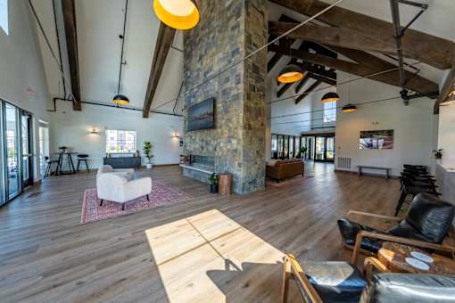 A living room with a stone pillar and wooden floors. at Silverbrook Apartments, Kalispell, MT