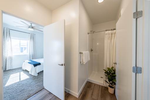 A white bathroom with a bed in the background. at Silverbrook Apartments, Montana, 59901