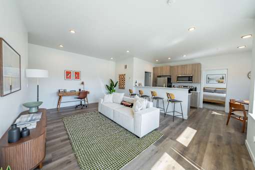 A living room with a white couch and a green rug. at Silverbrook Apartments, Kalispell, MT, 59901