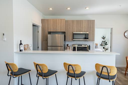 A kitchen with a white counter and four chairs. at Silverbrook Apartments, Kalispell, MT, 59901