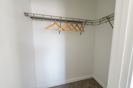 A white wall with a metal rack and hangers. at Silverbrook Apartments, Montana