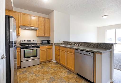 A kitchen with wooden cabinets and granite countertops.