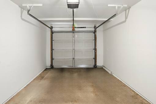 A white wall with a metal gate and a light on the ceiling.