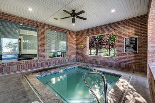 the indoor spa with brick walls and a ceiling fan at Eagles Landing Apartments, Ammon