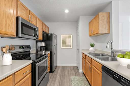 A kitchen with wooden cabinets and black appliances. at Eagles Landing, Ammon, 83406