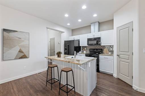 A kitchen with white cabinets and a marble countertop. at Verraso Village Apartments, Idaho