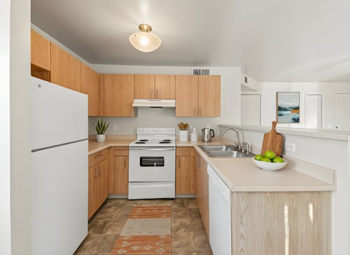 A kitchen with wooden cabinets and a white refrigerator.