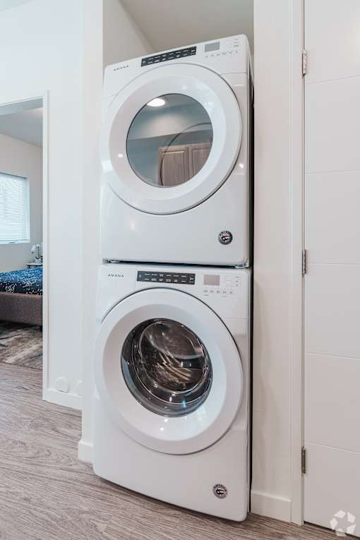 A white front load washing machine in a modern laundry room.