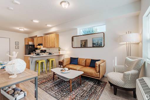 A living room with a couch, chair, and dining table.