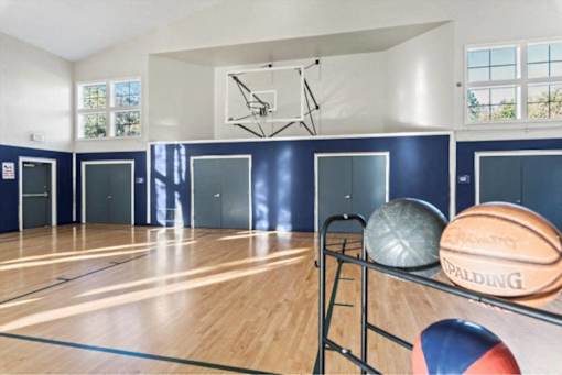 Indoor basketball court with sports equipment storage at Edgewater Apartments, Idaho