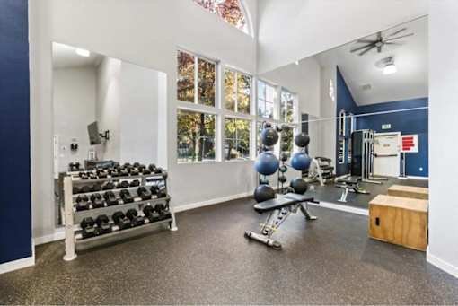 Well equipped fitness room with dumbbells and exercise bench at Edgewater Apartments, Boise, Idaho