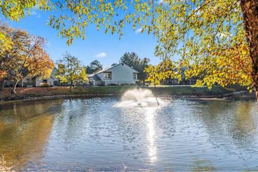 Pond with water fountain surrounded by fall trees at Edgewater Apartments, Idaho, 83703