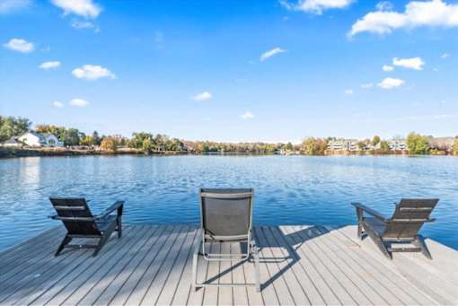 Waterfront deck with chairs overlooking lake at Edgewater Apartments, Boise, ID