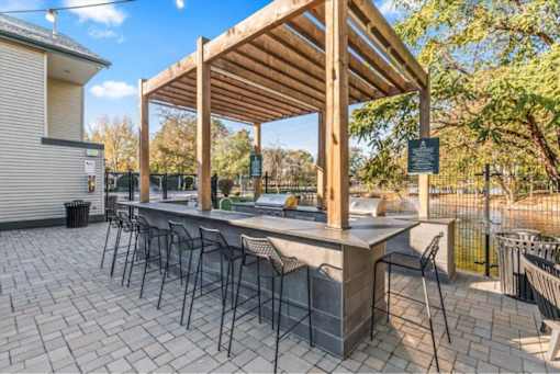 Outdoor kitchen bar with pergola and seating at Edgewater Apartments, Boise
