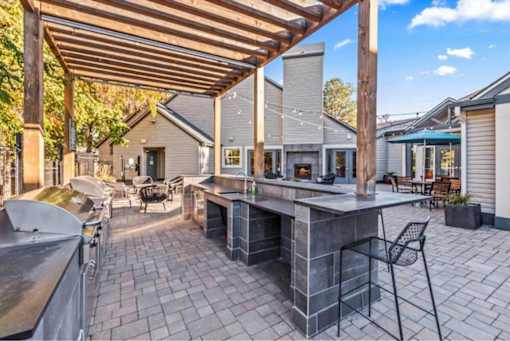 Outdoor kitchen island with pergola and patio seating at Edgewater Apartments, Idaho, 83703
