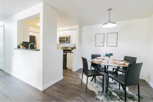 Modern dining area with glass table and pendant lighting at Edgewater Apartments, Boise, ID 83703