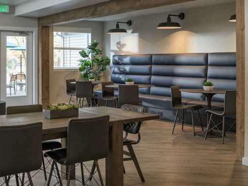 Modern dining area with banquette seating and industrial lighting at Edgewater Apartments, Boise, Idaho
