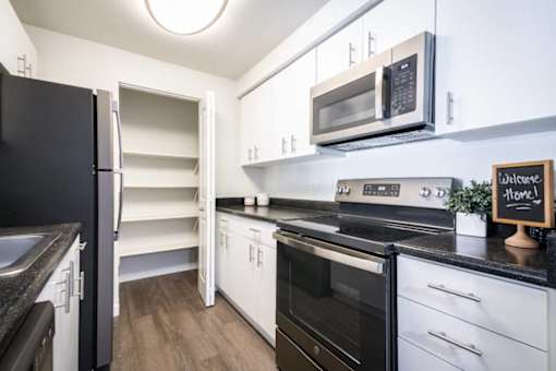 Galley kitchen with walk-in pantry and white cabinets at Edgewater Apartments, Idaho, 83703