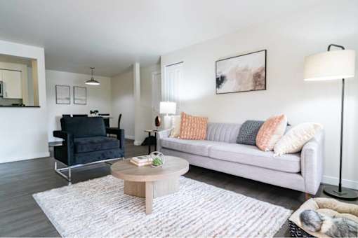 Contemporary living room with gray sofa and colorful pillows at Edgewater Apartments, Boise, ID