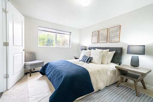 Modern bedroom with navy blue bedding and wooden nightstand at Edgewater Apartments, Boise, ID 83703
