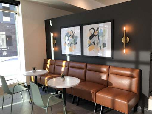 Stylish resident lounge at Morrow Apartments in St. Paul, MN, featuring modern leather cafe-style seating.