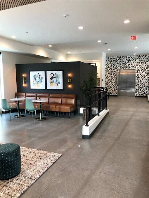 Modern lobby and elevator at Morrow Apartments in St. Paul, MN, with designer seating and contemporary finishes.