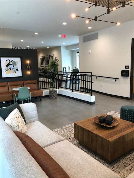 A living room with a couch, a coffee table, and a staircase.