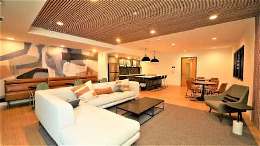 Modern community clubroom at Morrow Apartments in St. Paul near the Green Line with social seating and a kitchen.