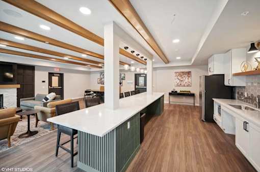 A modern kitchen with a white countertop and wooden flooring.