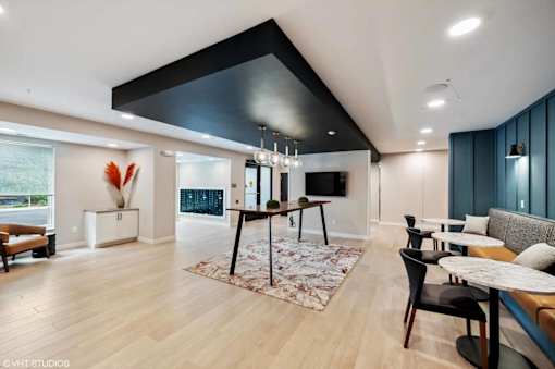 A modern living room with a black ceiling and wooden floors.