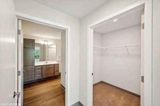 A white bathroom with a walk in closet.