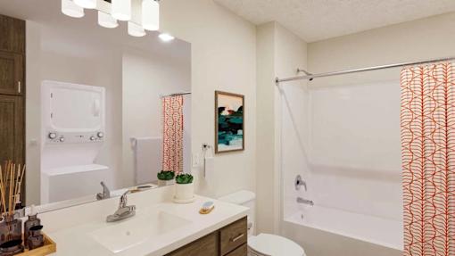 A bathroom with a white sink and a white toilet.