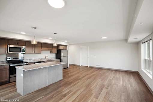 A modern kitchen with wooden floors and a large island.