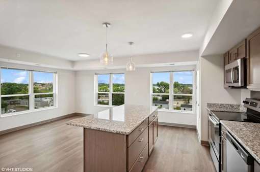 A kitchen with a granite countertop and a view of the outdoors through the windows.