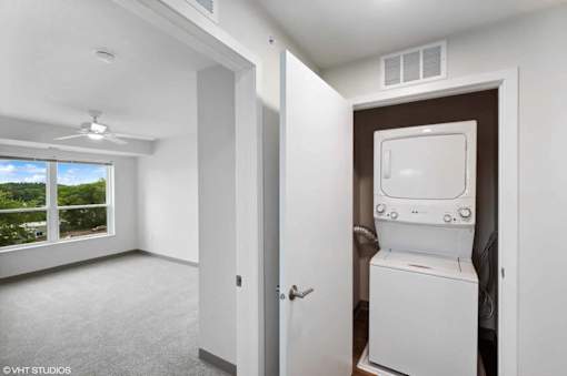 A white room with a window and a washing machine.