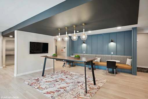 A modern dining room with a large table and chairs.