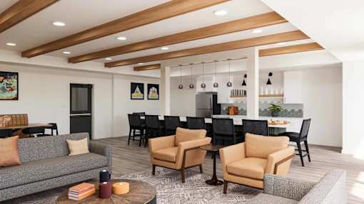 A living room with a grey sofa, black chairs, and a wooden coffee table.