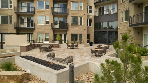 an outdoor patio with a fire pit and a building in the background at Cycle Apartments, Colorado