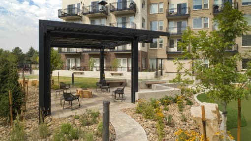 an outdoor patio with a fire pit and a building in the background at Cycle Apartments, Fort Collins, Colorado