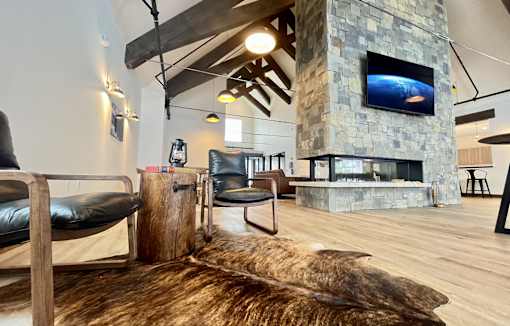 A modern living room with a stone fireplace and a large flat screen TV mounted above it at Silverbrook Apartments Apartments, Ridgeland, MT