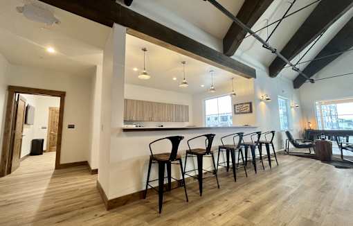 A room with wooden floors and a bar area with chairs at Silverbrook Apartments Apartments, Kalispell