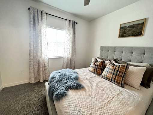 A bedroom with a large bed and a window with curtains at Silverbrook Apartments Apartments, Kalispell, 59901