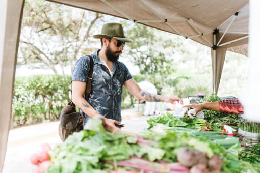 a man buying vegetables at a farmers market at Copestone, Garden City, ID