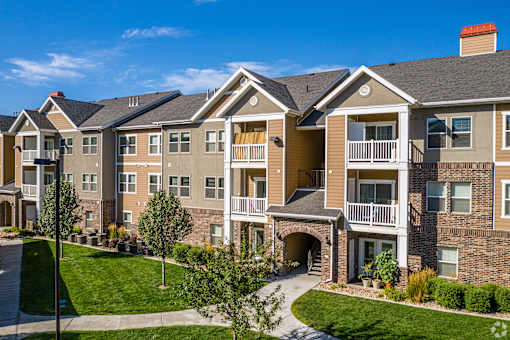 A large apartment complex with a well-maintained lawn and landscaping.